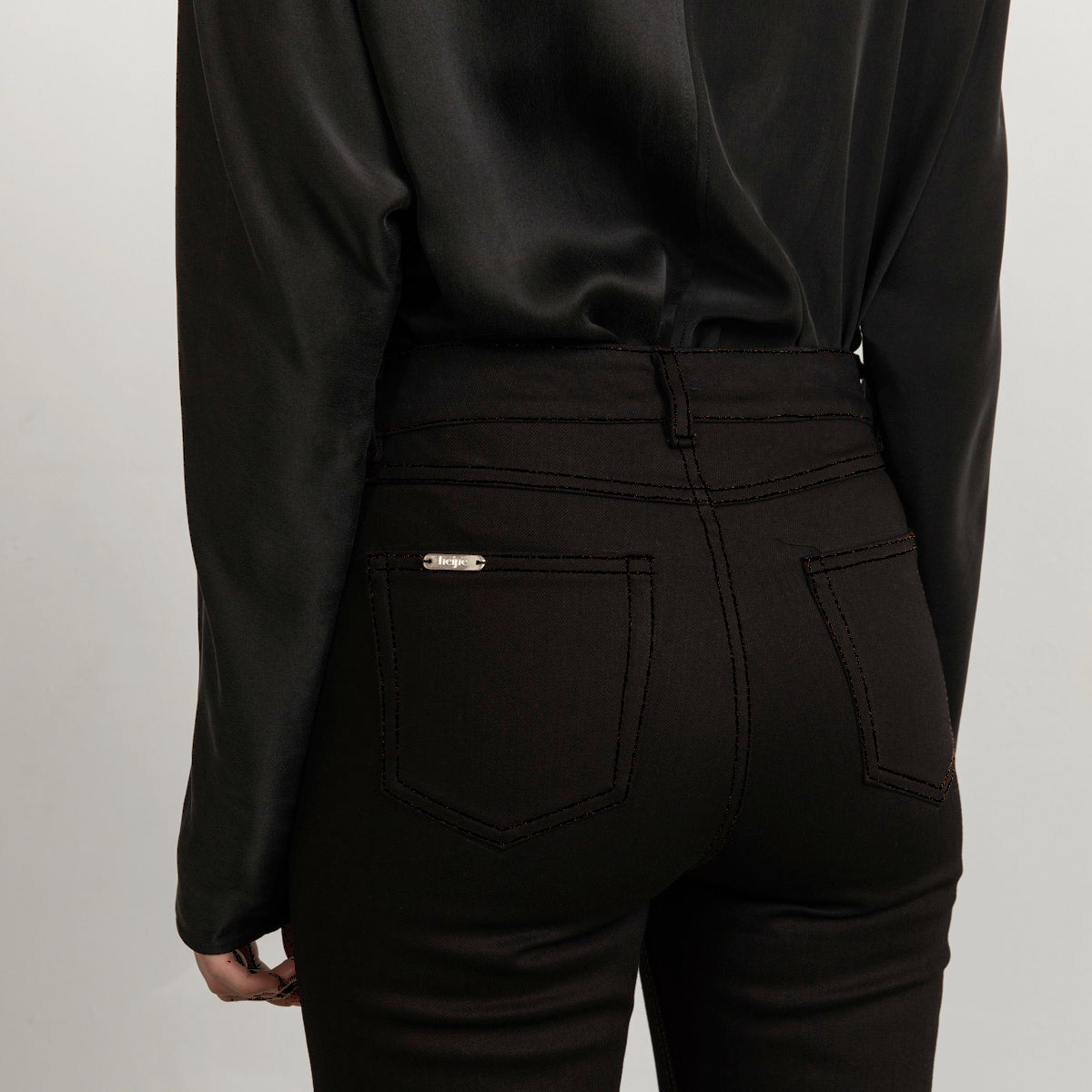 Flared black jeans with matching stitch, cropped