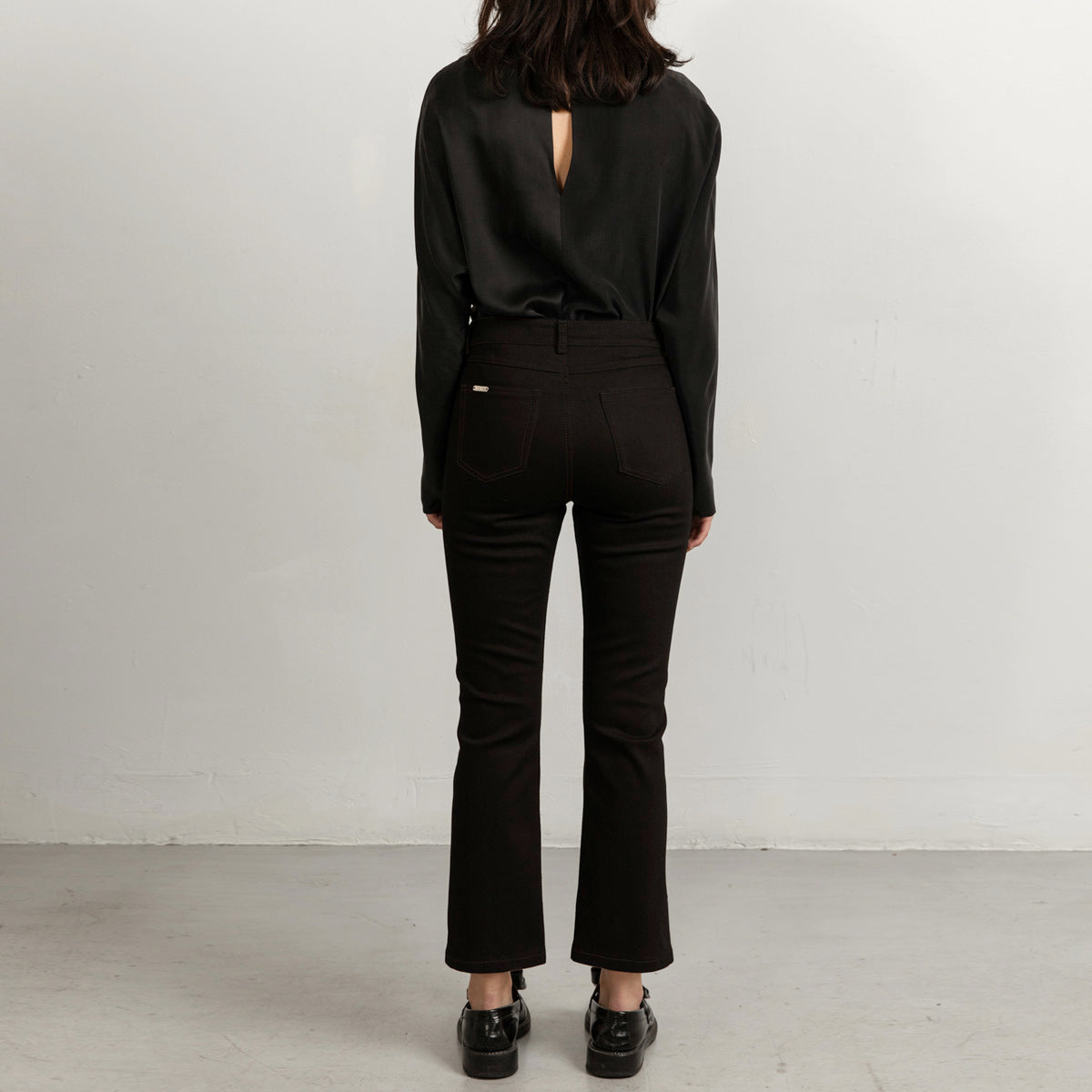 Flared black jeans with matching stitch, cropped