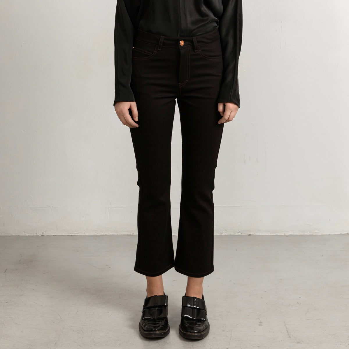 Flared black jeans with matching stitch, cropped